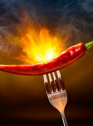 Flamed fire blaze red chilli on steel fork